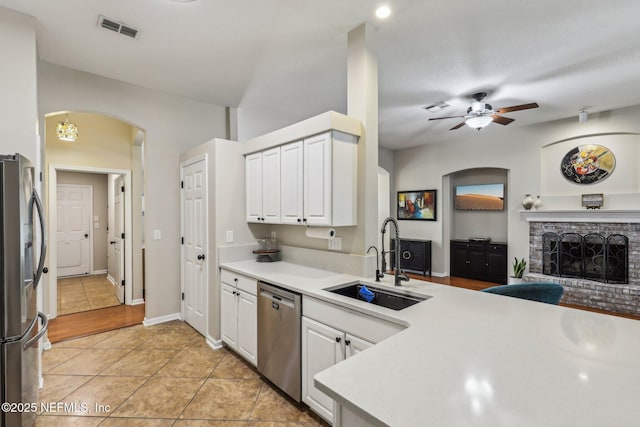 1346 N Kyle Way, Jacksonville, FL 32259 - kitchen with stainless steel appliances, a sink, arched walkways, ceiling fan, and white cabinetry