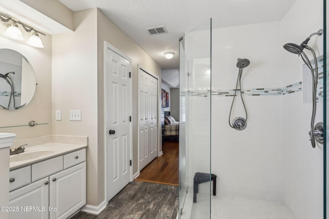 1346 N Kyle Way, Jacksonville, FL 32259 - bathroom featuring tiled shower, vanity, wood finished floors, ensuite bath, and a textured ceiling
