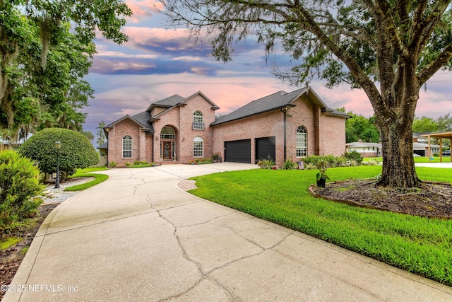 6449 Jack Wright Island Rd, Saint Augustine, FL 32092 - french country style house with brick siding, an attached garage, concrete driveway, and a front yard