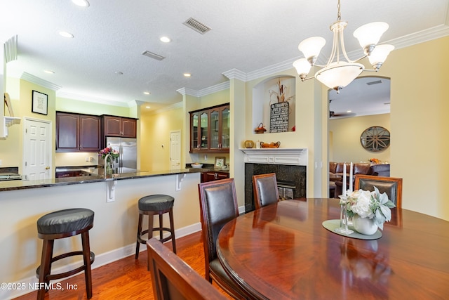 6449 Jack Wright Island Rd, Saint Augustine, FL 32092 - dining room featuring wood finished floors, recessed lighting, a chandelier, ornamental molding, and a high end fireplace