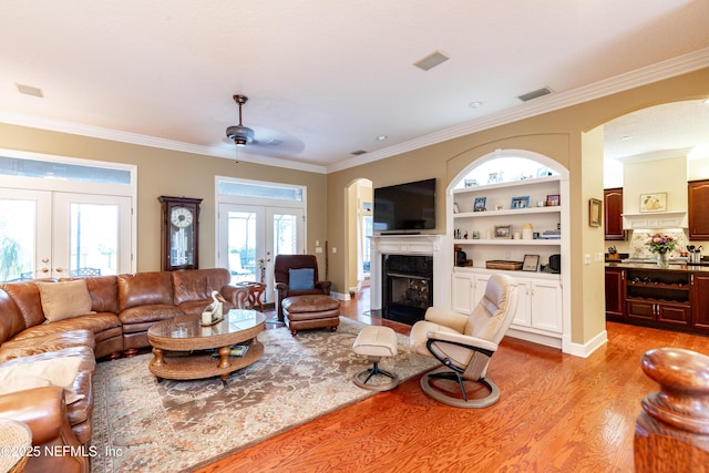 6449 Jack Wright Island Rd, Saint Augustine, FL 32092 - living area featuring french doors, arched walkways, ornamental molding, light wood finished floors, and built in features
