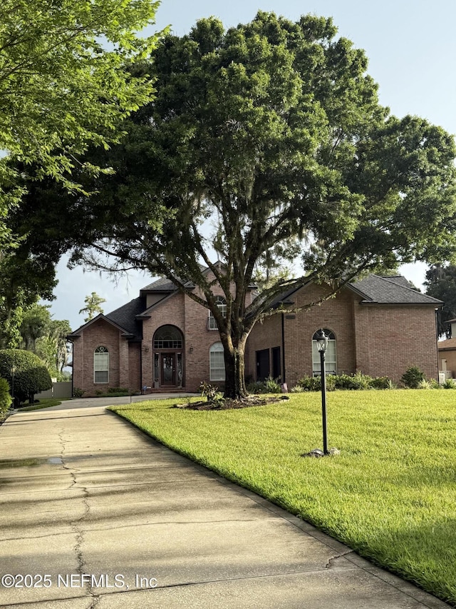 6449 Jack Wright Island Rd, Saint Augustine, FL 32092 - view of front of property with brick siding, a front yard, and a shingled roof