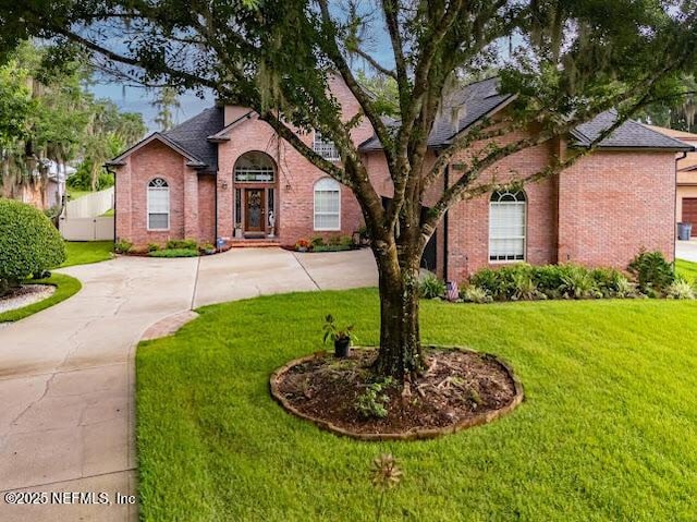 6449 Jack Wright Island Rd, Saint Augustine, FL 32092 - traditional-style home featuring brick siding, a front yard, and roof with shingles