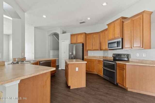 3353 Horseshoe Trail Dr, Orange Park, FL 32065 - kitchen with appliances with stainless steel finishes, a sink, light countertops, a textured ceiling, and a center island