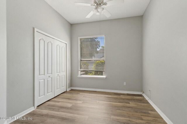 3353 Horseshoe Trail Dr, Orange Park, FL 32065 - unfurnished bedroom featuring wood finished floors, a closet, baseboards, and ceiling fan