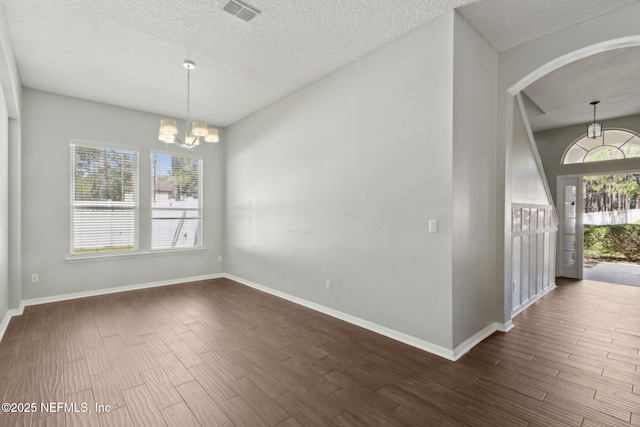 3353 Horseshoe Trail Dr, Orange Park, FL 32065 - unfurnished dining area featuring a chandelier, a textured ceiling, arched walkways, dark wood-style flooring, and baseboards