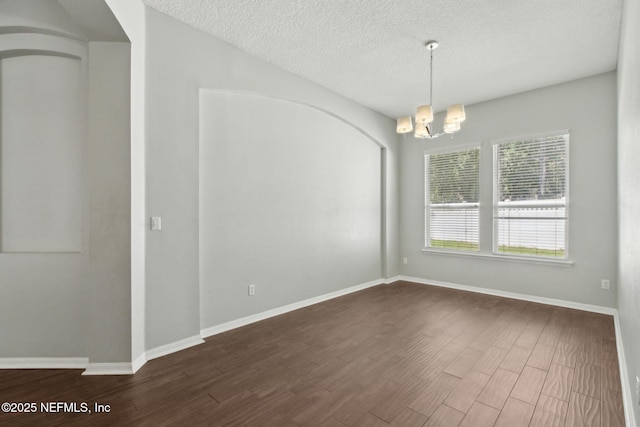 3353 Horseshoe Trail Dr, Orange Park, FL 32065 - spare room featuring a chandelier, dark wood finished floors, a textured ceiling, baseboards, and arched walkways
