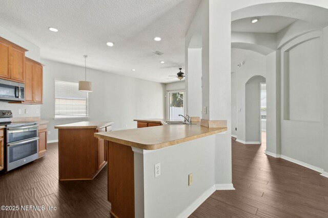 3353 Horseshoe Trail Dr, Orange Park, FL 32065 - kitchen with stainless steel appliances, a sink, arched walkways, a center island, and ceiling fan