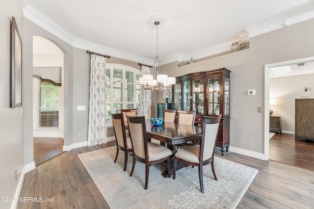 1758 Country Walk Dr, Fleming Island, FL 32003 - dining area featuring a chandelier, wood finished floors, crown molding, and arched walkways