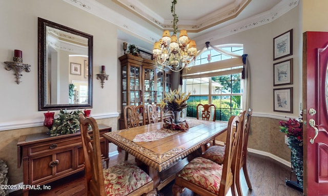 1700 Waters Edge Dr, Fleming Island, FL 32003 - dining space featuring a chandelier, wood finished floors, wainscoting, ornamental molding, and a raised ceiling