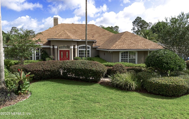 1700 Waters Edge Dr, Fleming Island, FL 32003 - view of front of house with stucco siding, a front lawn, a chimney, and roof with shingles
