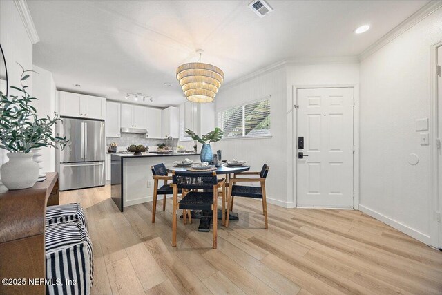 1800 The Greens Way Unit 1907, Jacksonville Beach, FL 32250 - dining area with light wood-type flooring, a chandelier, ornamental molding, and baseboards