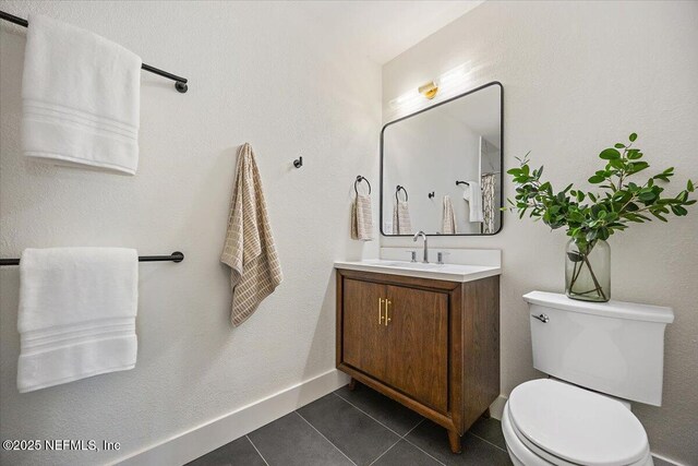 1800 The Greens Way Unit 1907, Jacksonville Beach, FL 32250 - bathroom featuring vanity, toilet, tile patterned flooring, and baseboards