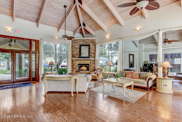 1800 The Greens Way Unit 1907, Jacksonville Beach, FL 32250 - living area featuring a ceiling fan, wood ceiling with exposed beams, wood-type flooring, a brick fireplace, and high vaulted ceiling