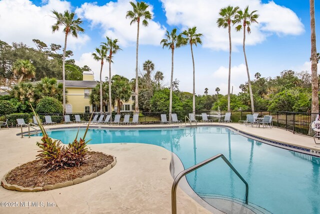 1800 The Greens Way Unit 1907, Jacksonville Beach, FL 32250 - community pool with a patio area and view of wooded area