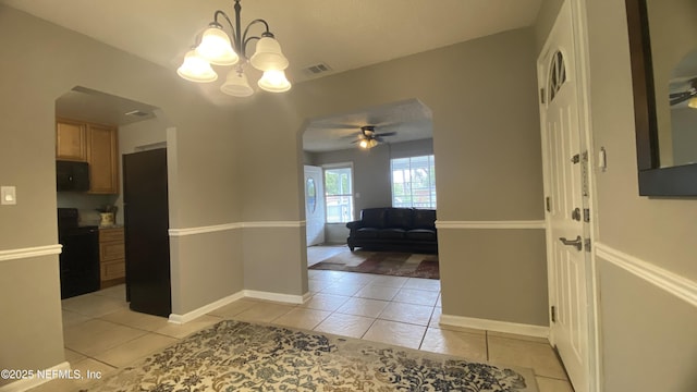 5923 Green Hill Ln, Jacksonville, FL 32211 - corridor featuring light tile patterned flooring, a chandelier, arched walkways, and baseboards