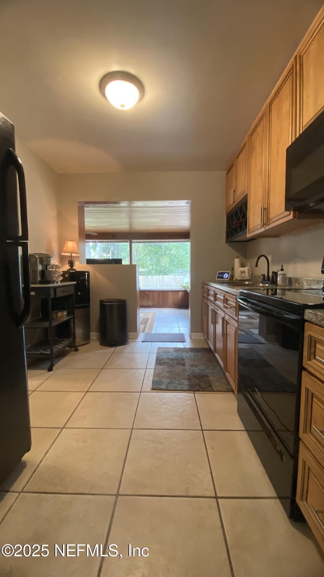 5923 Green Hill Ln, Jacksonville, FL 32211 - kitchen with black appliances, light tile patterned flooring, brown cabinetry, dark countertops, and baseboards