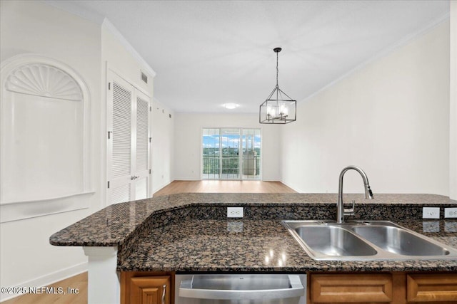 150 Pantano Cay Blvd Unit 2303, Saint Augustine, FL 32080 - kitchen featuring stainless steel dishwasher, brown cabinets, wood finished floors, dark stone counters, and a chandelier