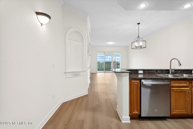150 Pantano Cay Blvd Unit 2303, Saint Augustine, FL 32080 - kitchen with dishwasher, brown cabinetry, light wood-style floors, decorative light fixtures, and dark stone countertops