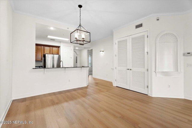 150 Pantano Cay Blvd Unit 2303, Saint Augustine, FL 32080 - unfurnished living room featuring ornamental molding, light wood finished floors, and a chandelier