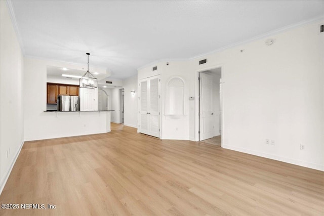 150 Pantano Cay Blvd Unit 2303, Saint Augustine, FL 32080 - unfurnished living room with light wood-type flooring, ornamental molding, and a chandelier