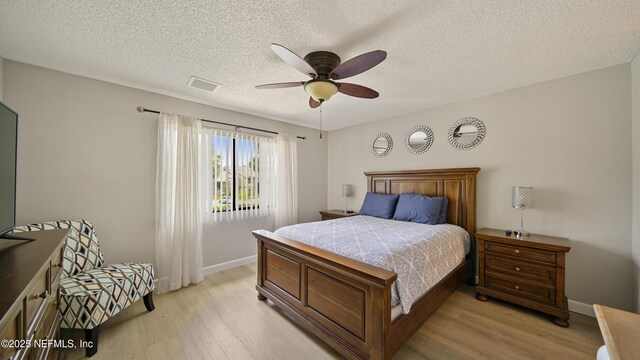 87 Village Del Lago Cir, Saint Augustine, FL 32080 - bedroom with light wood-type flooring, baseboards, ceiling fan, and a textured ceiling