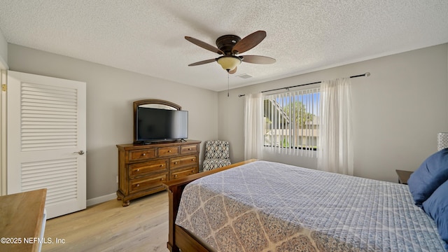 87 Village Del Lago Cir, Saint Augustine, FL 32080 - bedroom with light wood-style flooring, a textured ceiling, baseboards, and ceiling fan