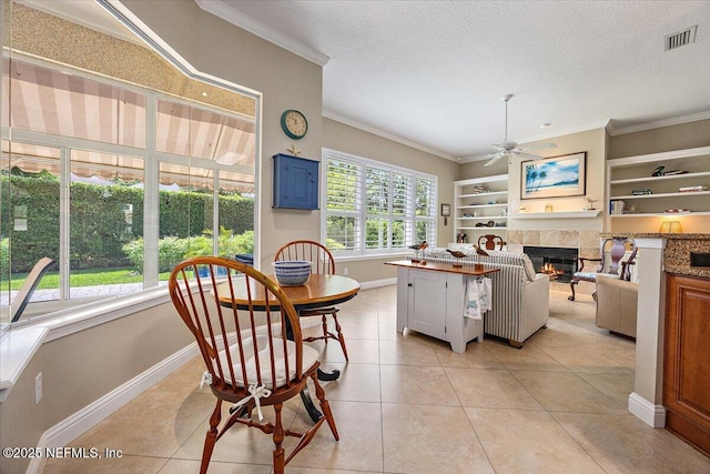 6541 Burnham Cir, Ponte Vedra Beach, FL 32082 - dining space with baseboards, a ceiling fan, crown molding, a tiled fireplace, and light tile patterned floors