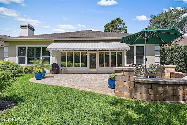 6541 Burnham Cir, Ponte Vedra Beach, FL 32082 - back of house featuring a patio area, a lawn, a chimney, roof with shingles, and stucco siding