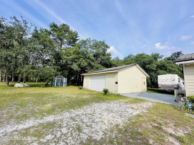 417 2nd Ave, Satsuma, FL 32189 - view of grassy yard featuring an outbuilding, an exterior structure, a garage, and view of wooded area