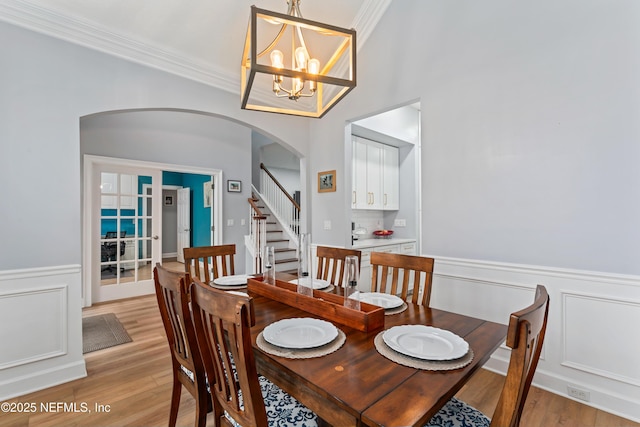 1321 Honeysuckle Dr, Saint Johns, FL 32259 - dining space featuring arched walkways, a chandelier, light wood-type flooring, a wainscoted wall, and ornamental molding