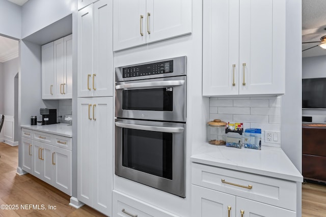 1321 Honeysuckle Dr, Saint Johns, FL 32259 - kitchen with double oven, tasteful backsplash, wood finished floors, white cabinets, and arched walkways