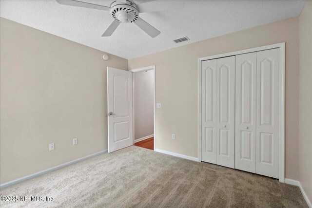8681 Canopy Oaks Dr, Jacksonville, FL 32256 - unfurnished bedroom featuring carpet, a closet, baseboards, a textured ceiling, and ceiling fan