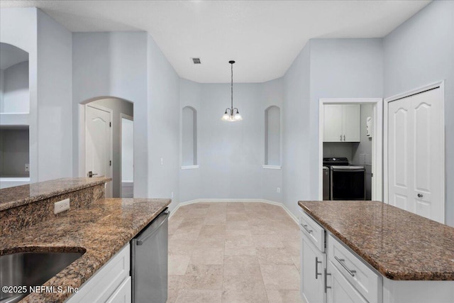 8681 Canopy Oaks Dr, Jacksonville, FL 32256 - kitchen featuring stainless steel dishwasher, arched walkways, white cabinetry, washer and dryer, and dark stone counters