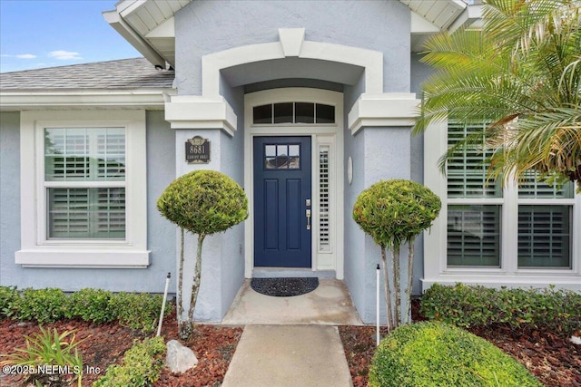 8681 Canopy Oaks Dr, Jacksonville, FL 32256 - entrance to property featuring stucco siding and roof with shingles