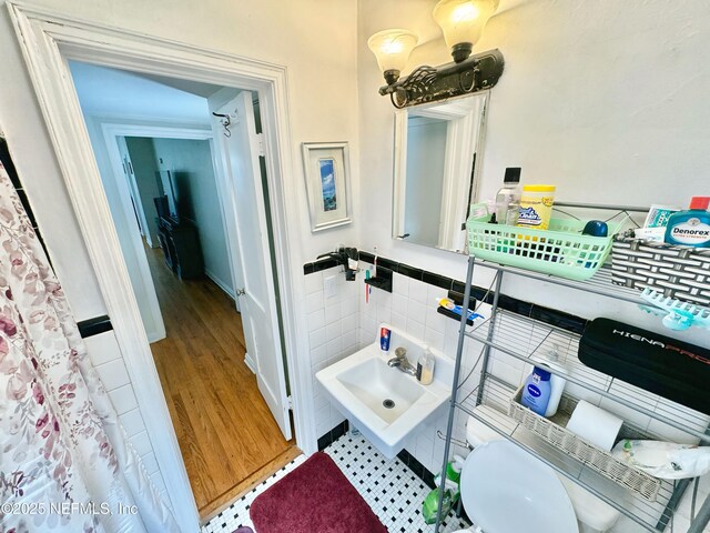 1966 Lakewood Cir S, Jacksonville, FL 32207 - bathroom featuring tile walls, a wainscoted wall, and wood finished floors