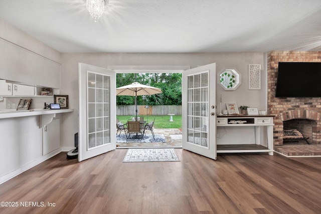 2620 Shenandoah Dr S, Orange Park, FL 32073 - living room featuring french doors, wood finished floors, and a brick fireplace