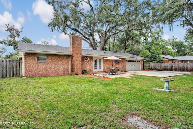 2620 Shenandoah Dr S, Orange Park, FL 32073 - back of house with a garage, a chimney, driveway, french doors, and brick siding