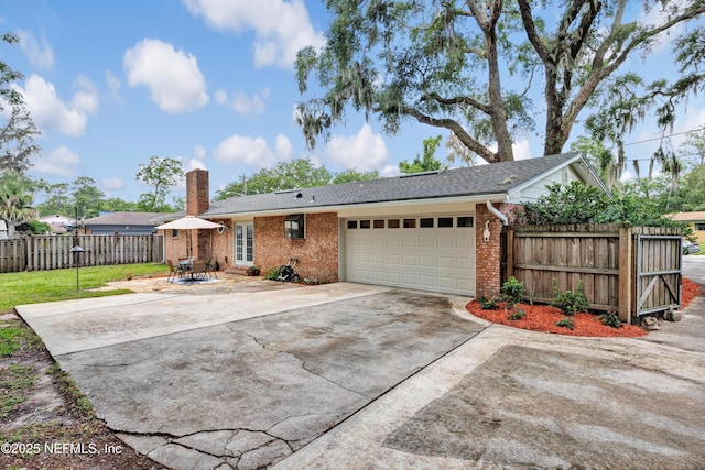 2620 Shenandoah Dr S, Orange Park, FL 32073 - rear view of house with a garage, driveway, brick siding, and a chimney