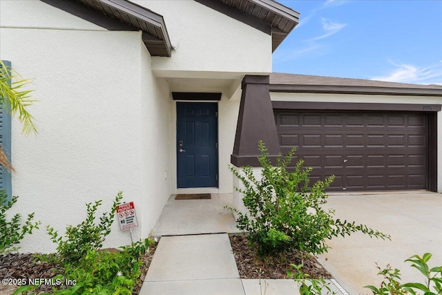 1976 Red Loop, Lakeland, FL 33801 - entrance to property with stucco siding, driveway, and an attached garage