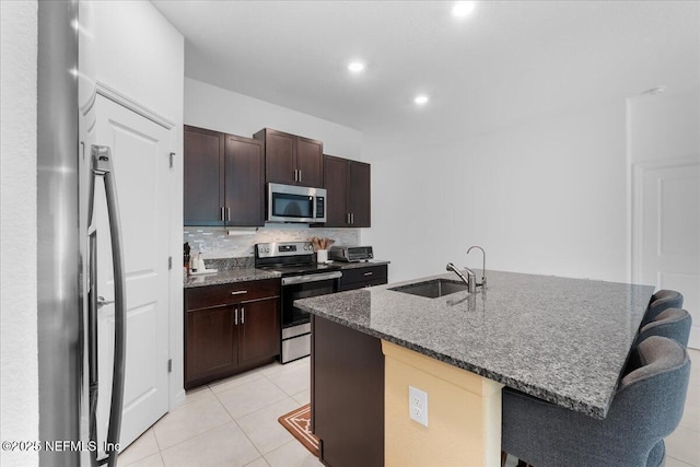 1976 Red Loop, Lakeland, FL 33801 - kitchen with stainless steel appliances, a sink, a center island with sink, dark stone countertops, and tasteful backsplash