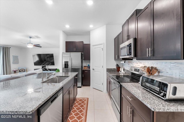 1976 Red Loop, Lakeland, FL 33801 - kitchen featuring appliances with stainless steel finishes, a sink, dark brown cabinets, open floor plan, and light tile patterned flooring