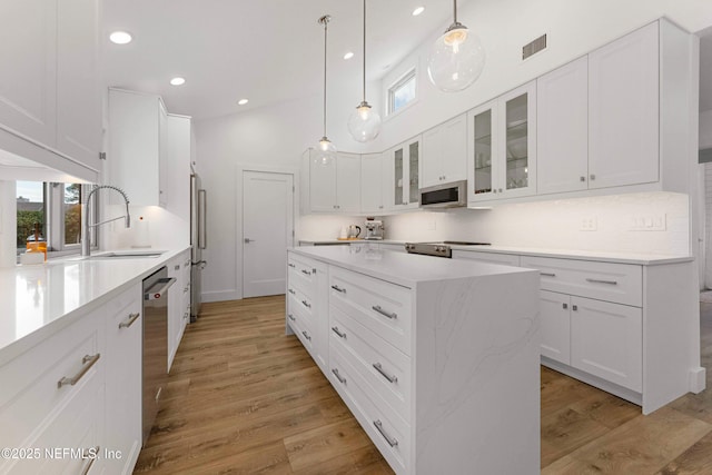 1 Lake Julia Dr S, Ponte Vedra Beach, FL 32082 - kitchen featuring stainless steel appliances, light wood-type flooring, a kitchen island, glass insert cabinets, and white cabinetry