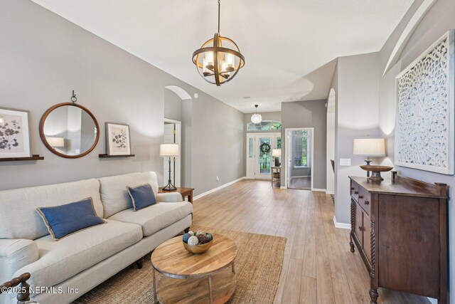 1823 Sentry Oak Ct, Fleming Island, FL 32003 - living area with light wood-type flooring, baseboards, a chandelier, and arched walkways
