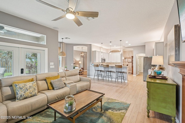 1823 Sentry Oak Ct, Fleming Island, FL 32003 - living room featuring ceiling fan, light wood-style floors, arched walkways, and baseboards