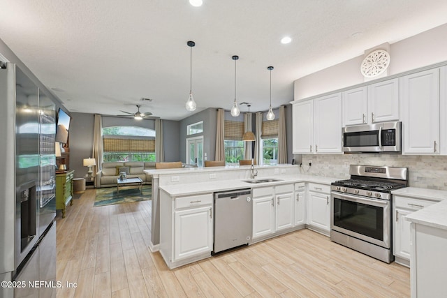 1823 Sentry Oak Ct, Fleming Island, FL 32003 - kitchen with appliances with stainless steel finishes, a peninsula, open floor plan, a sink, and light countertops