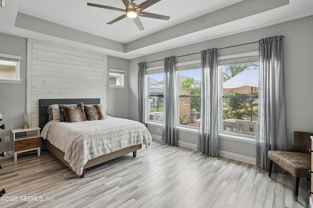 48 Foxcross Ave, Saint Augustine, FL 32092 - bedroom with a raised ceiling, light wood finished floors, baseboards, a large fireplace, and ceiling fan