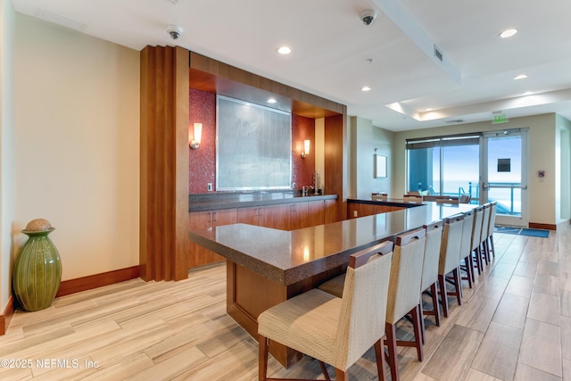 1925 S Atlantic Ave Unit 1005, Daytona Beach Shores, FL 32118 - kitchen with dark countertops, light wood-style flooring, baseboards, recessed lighting, and brown cabinets