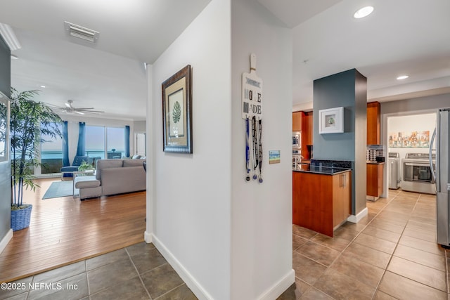 1925 S Atlantic Ave Unit 1005, Daytona Beach Shores, FL 32118 - hall featuring independent washer and dryer, light tile patterned floors, recessed lighting, and baseboards