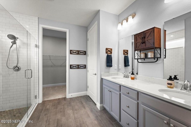 46 Killarney Ave, Saint Johns, FL 32259 - bathroom featuring a stall shower, double vanity, wood tiled floors, a walk in closet, and baseboards